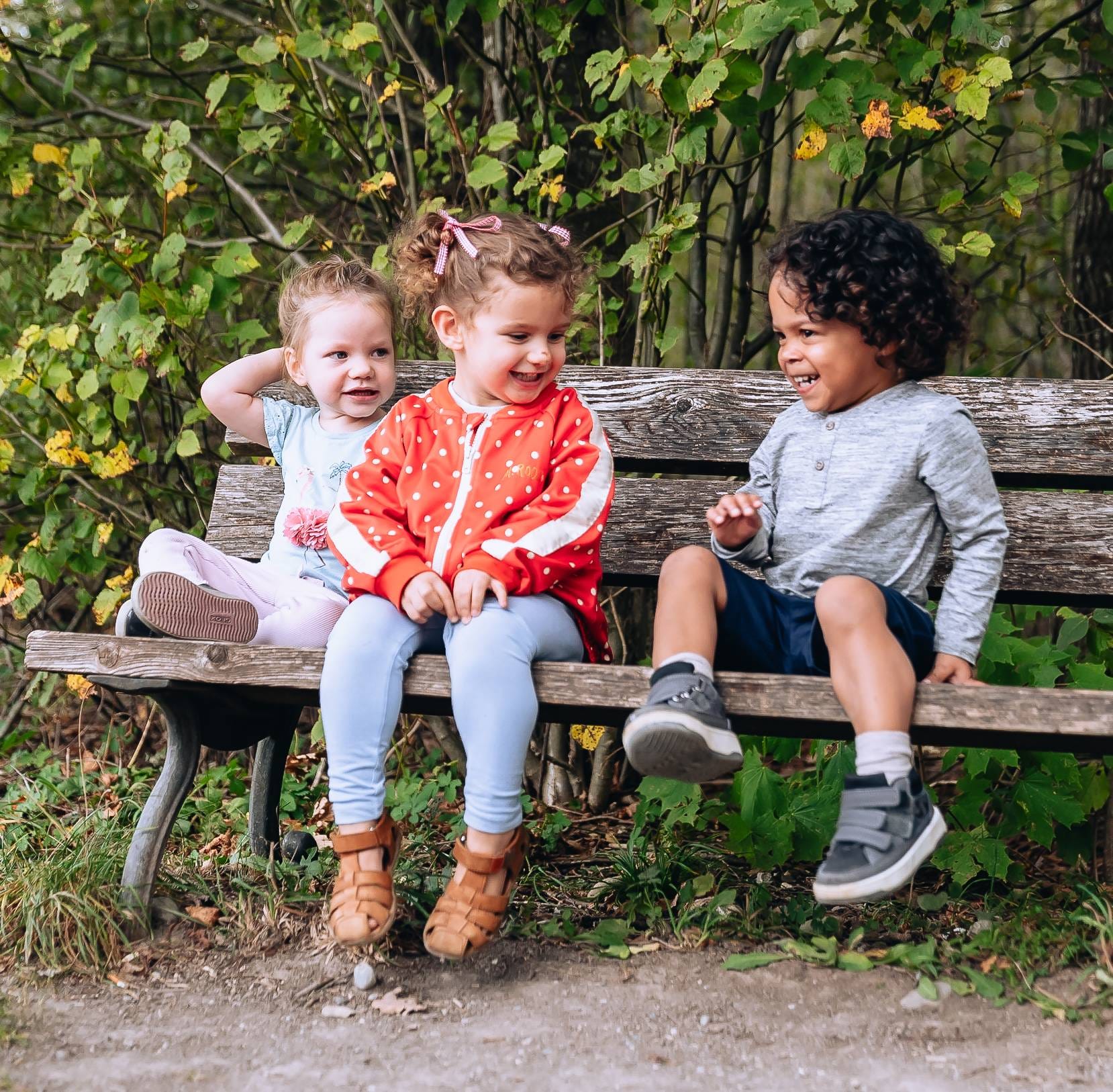 Children sitting together on a bench at Big Little Moments